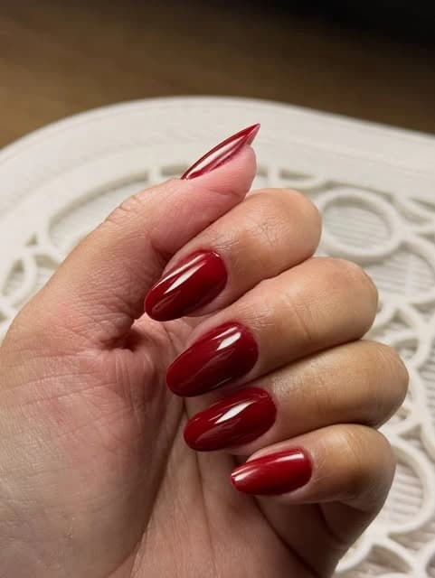 Unhas alongadas amendoadas com esmaltação vermelha brilhante
